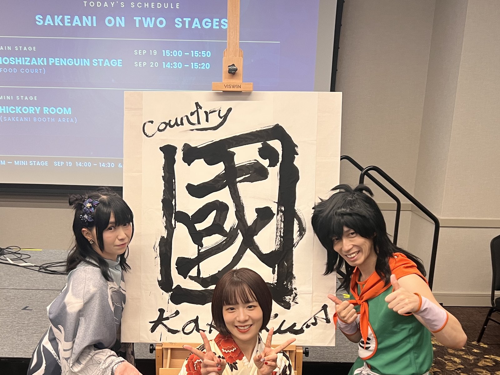 揮毫作品「國」と出演者3人